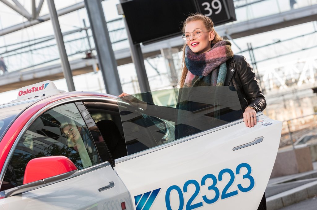 Bilde tatt av Oslo Taxi av en kvinne som entrer en taxi  Bilde tatt av Oslo Taxi av en kvinne som entrer en taxi