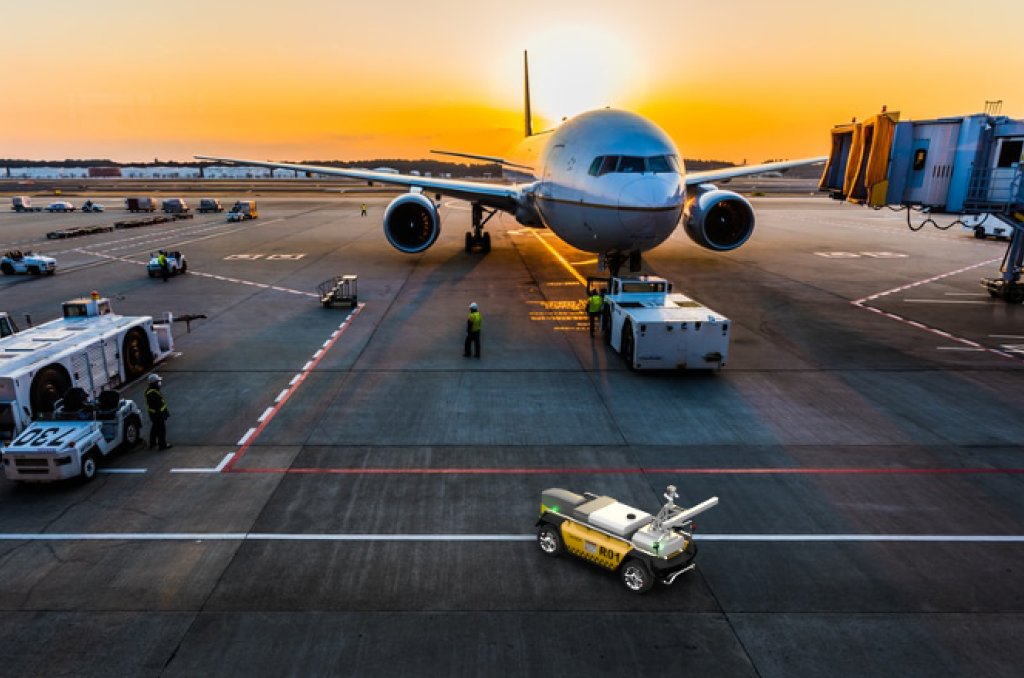 Bilde av en rullebane på en flyplass, hvor du ser et fly ved siden av roboten til Roboxi som Bouvet har fått tatt del i utviklingen av.  Bilde av en rullebane på en flyplass, hvor du ser et fly ved siden av roboten til Roboxi som Bouvet har fått tatt del i utviklingen av.