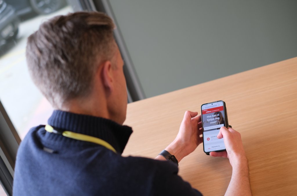 Bilde av Jørn fra Lyse som ser på mobilen sin hvor han har den nye Altibox-appen åpen. 