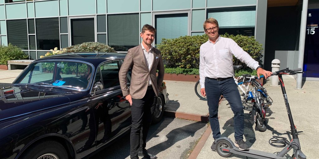 Kristian Amlie (til høyere) poserer sammen med kollega  Kjetil Høydal foran ulike kjøretøy