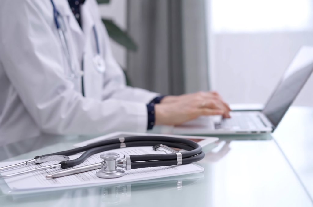 Bilde av en lege som bruker en PC Bilde av en lege som bruker en PC