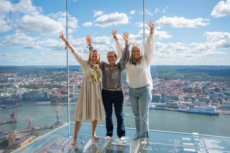 Bilde av tre av våre kolleger som smiler fornøyd med flott utsikt av Gøteborg bak dem. B
