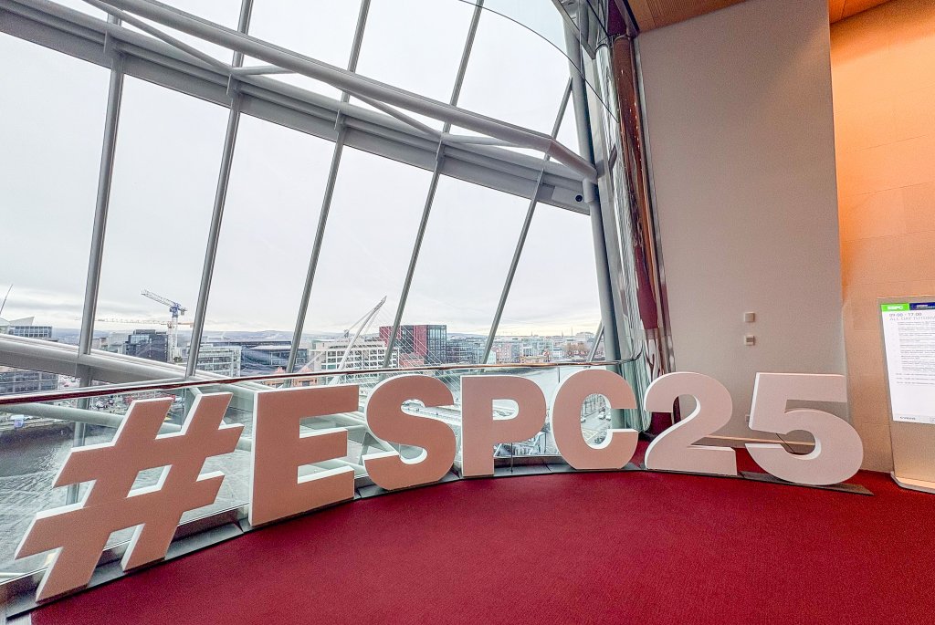 Bilde fra konferansen, her ser man logoen til konferansen ESPC25 i pappbokstaver foran en utsikt over byen