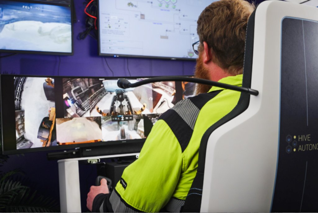 Bilde av operatør som sitter i et kontrollrom og fjernstyrer hjullasteren 